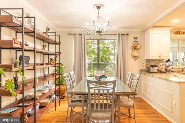 a dining room with furniture a chandelier and wooden floor