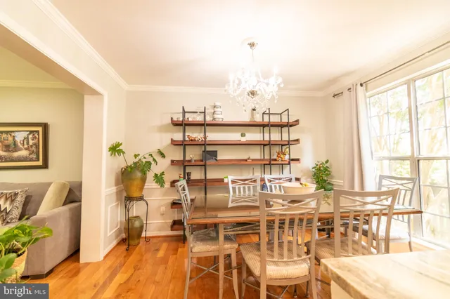 a view of a dining room with furniture a chandelier and wooden floor