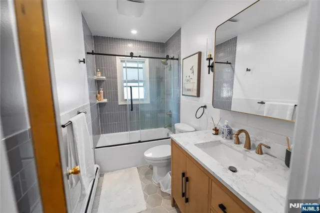 a bathroom with a granite countertop sink toilet and shower