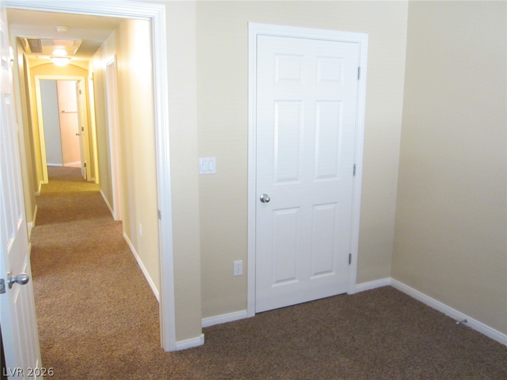 7701 West Robindale Road, Unit 262 Las Vegas, NV 89113 - Photo 15 of 26 A quiet hall with plush carpet leads to various rooms, promising comfort and privacy.