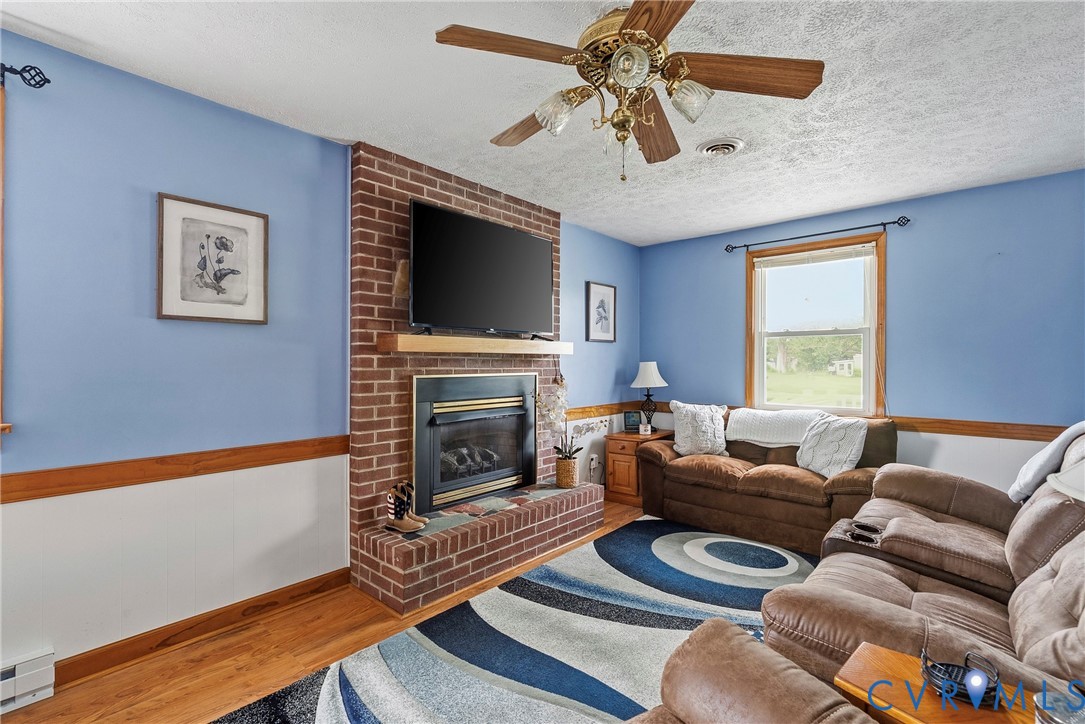 18024 Sandy Ford Road Petersburg, VA 23803 - Photo 14 of 66 a living room with furniture a flat screen tv and a fireplace