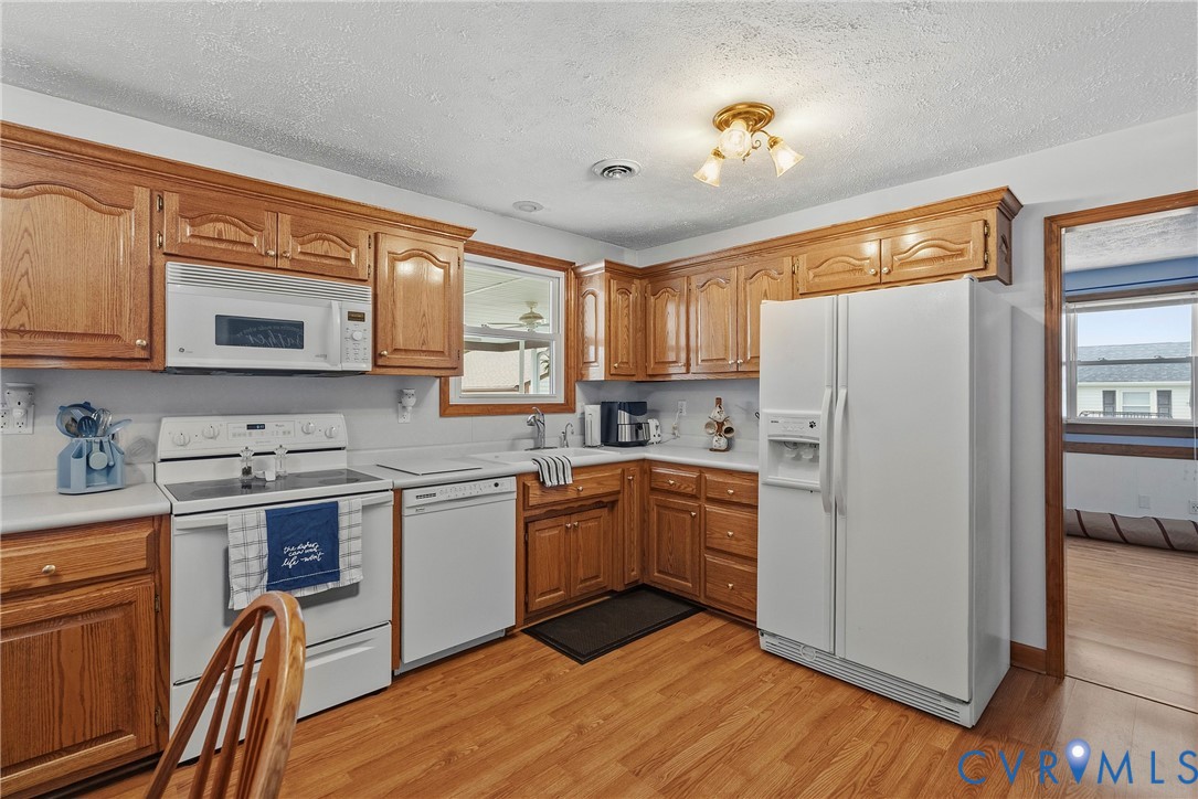 18024 Sandy Ford Road Petersburg, VA 23803 - Photo 20 of 66 a kitchen with stainless steel appliances granite countertop a refrigerator a stove top oven a sink dishwasher and white cabinets with wooden floor