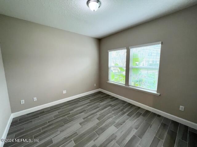 2333 Reese Way Jacksonville, FL 32246 - Photo 4 of 29 an empty room with wooden floor and windows