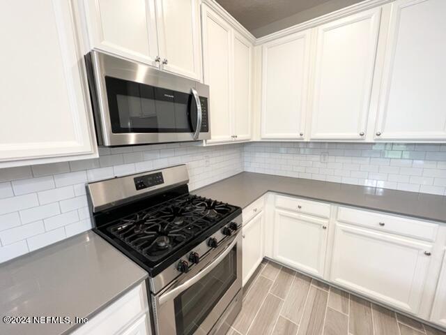 2333 Reese Way Jacksonville, FL 32246 - Photo 7 of 29 a kitchen with stainless steel appliances white cabinets and a stove top oven