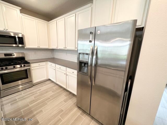 2333 Reese Way Jacksonville, FL 32246 - Photo 10 of 29 a kitchen with a refrigerator a microwave a sink and cabinets