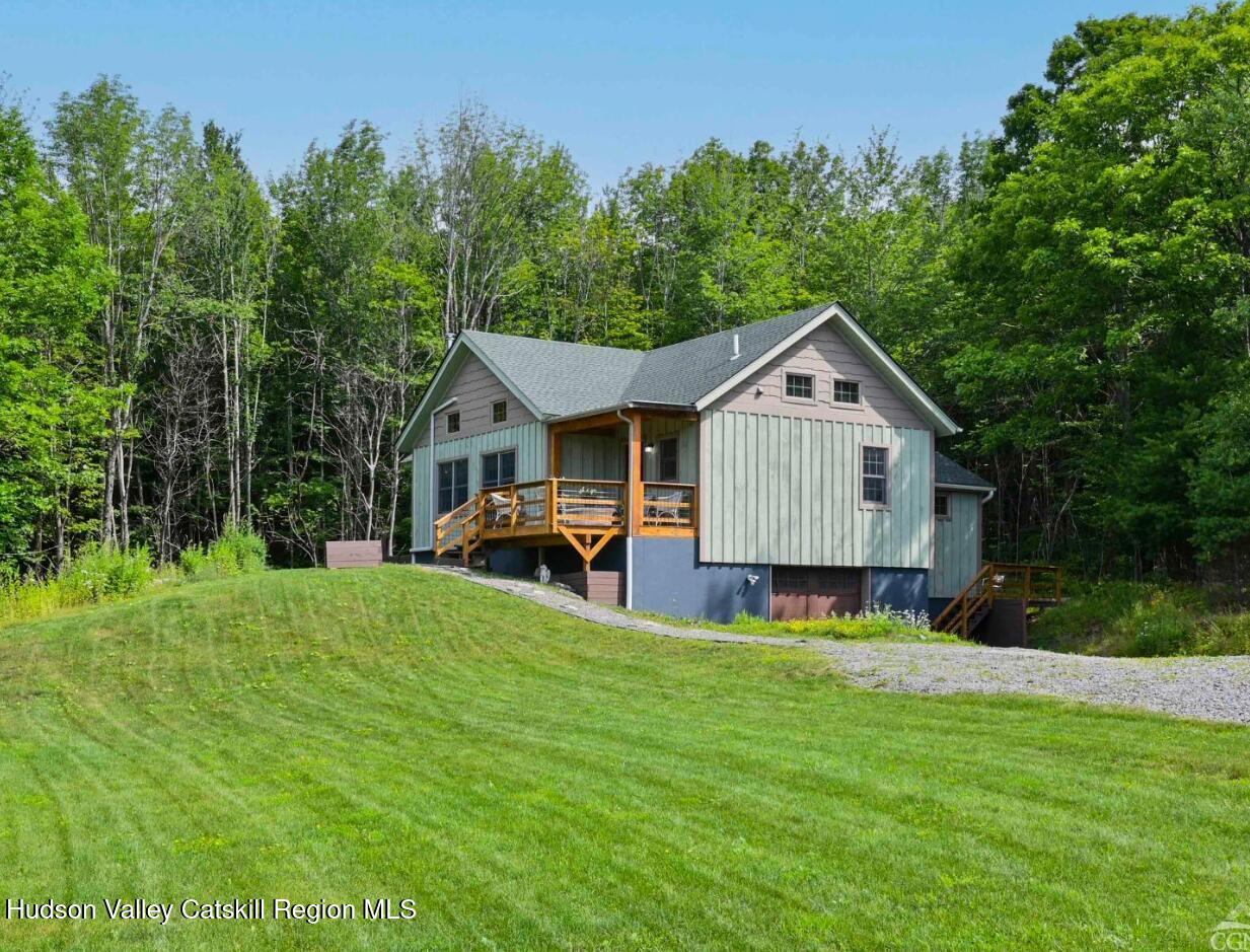 a view of a house with a yard and deck