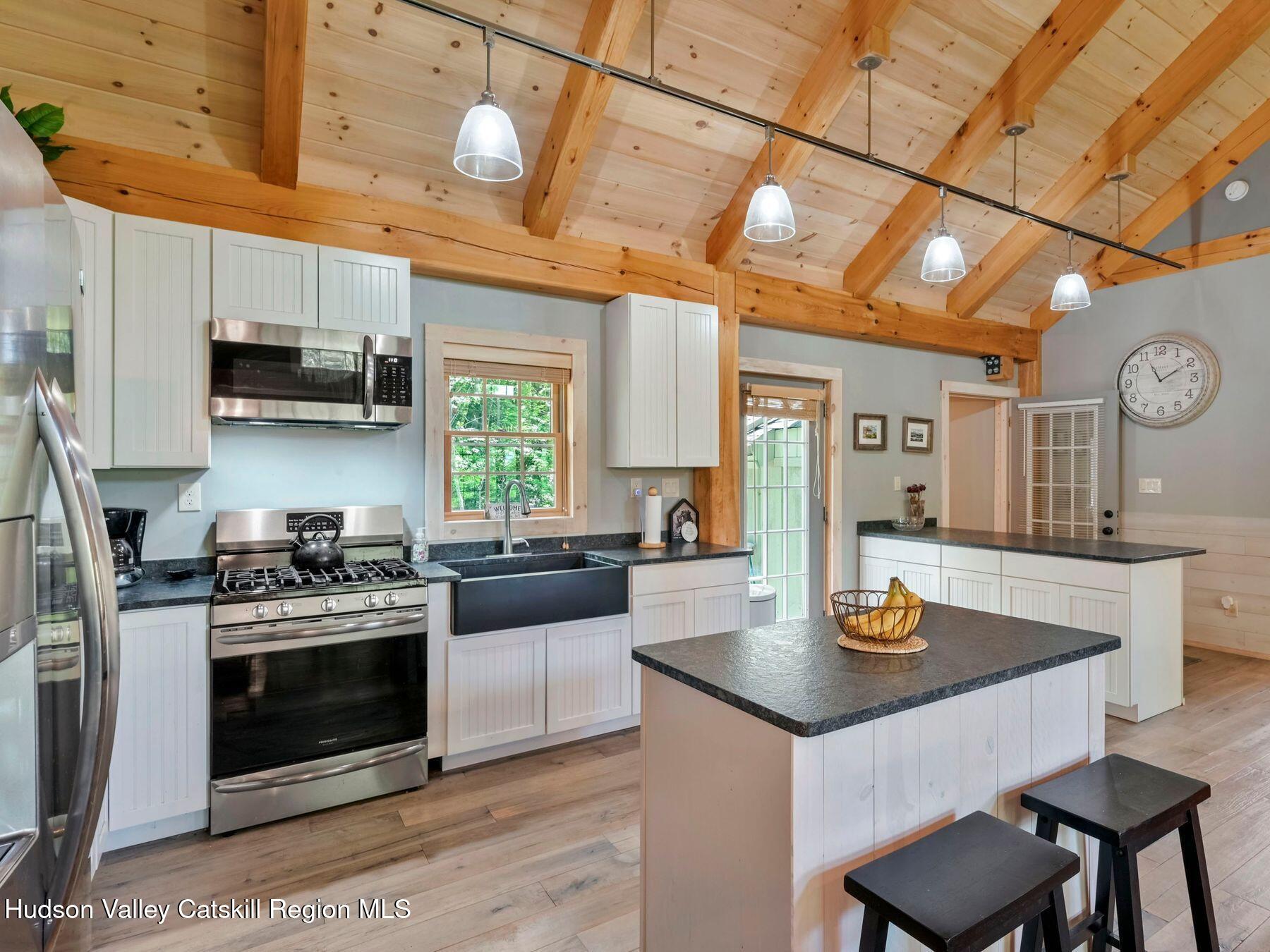 10 County Road Windham, NY 12496 - Photo 14 of 43 a kitchen with a stove a microwave and wooden floor