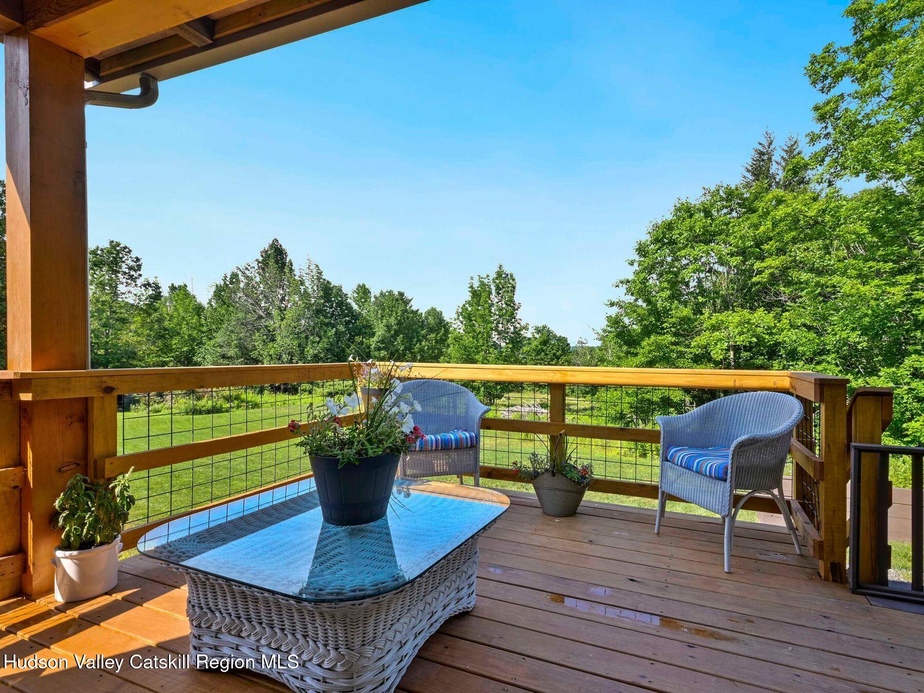 10 County Road Windham, NY 12496 - Photo 4 of 43 a view of a deck with a table chairs and a potted plant