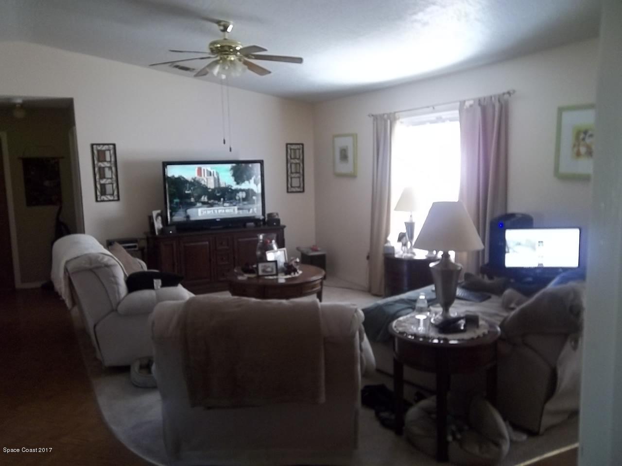 1081 Sapulpa Road Southwest Palm Bay, FL 32908 - Photo 2 of 10 a living room with furniture a large window and a flat screen tv