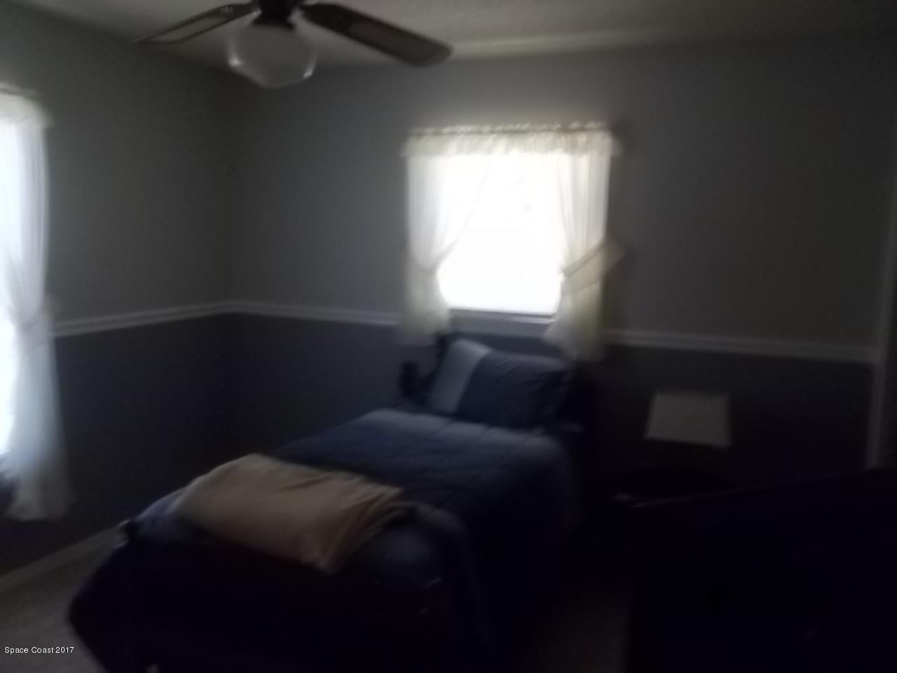 1081 Sapulpa Road Southwest Palm Bay, FL 32908 - Photo 7 of 10 a bed sitting in a bedroom next to a window
