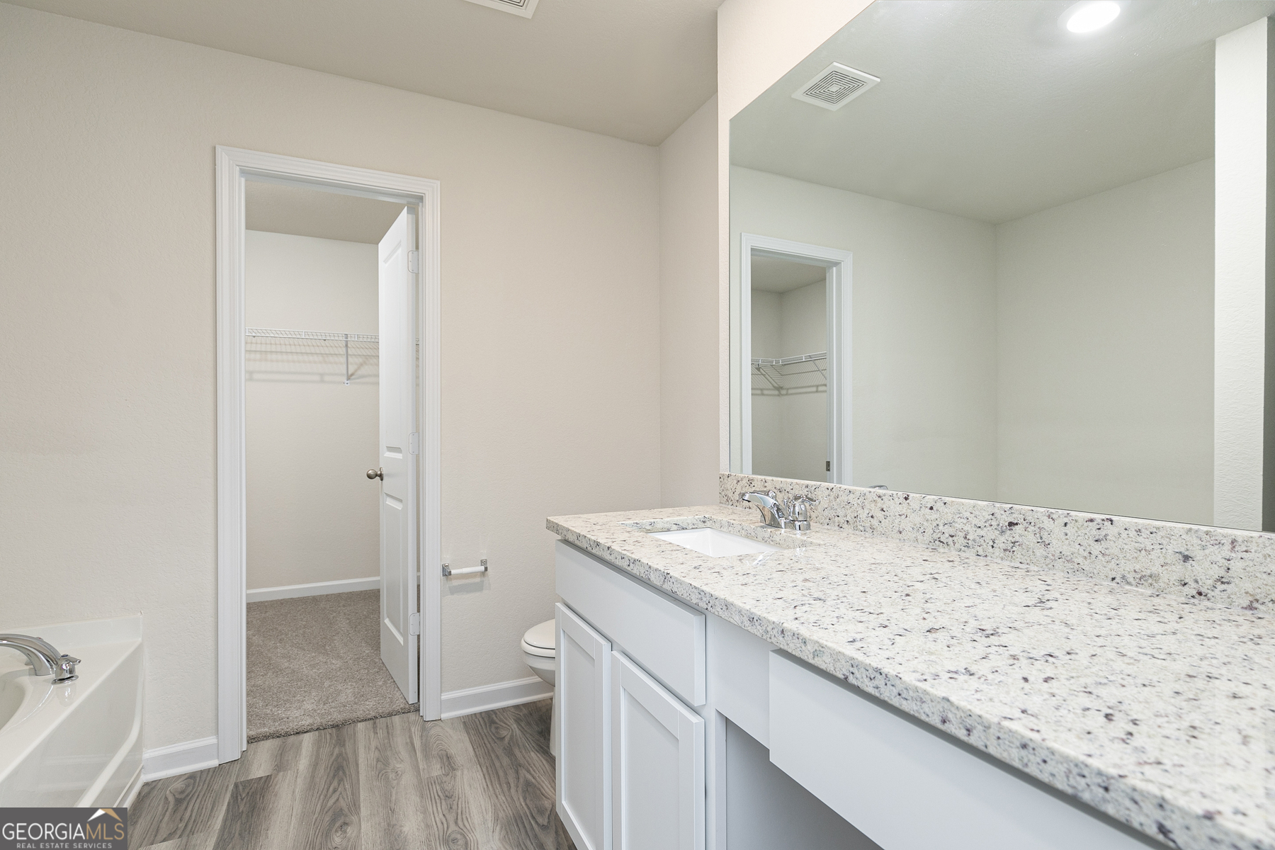 634 Slate Road Conyers, GA 30013 - Photo 16 of 22 a bathroom with a granite countertop sink and a mirror