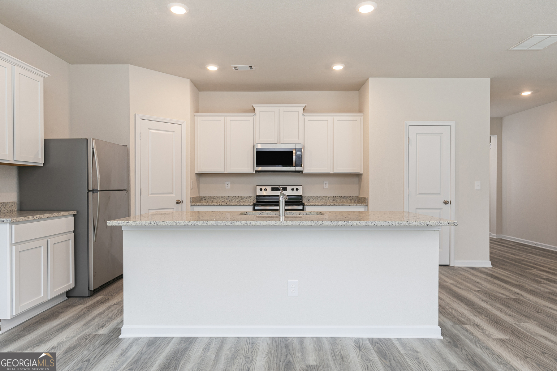634 Slate Road Conyers, GA 30013 - Photo 10 of 22 a kitchen with stainless steel appliances granite countertop a refrigerator a stove a sink and white cabinets with wooden floor