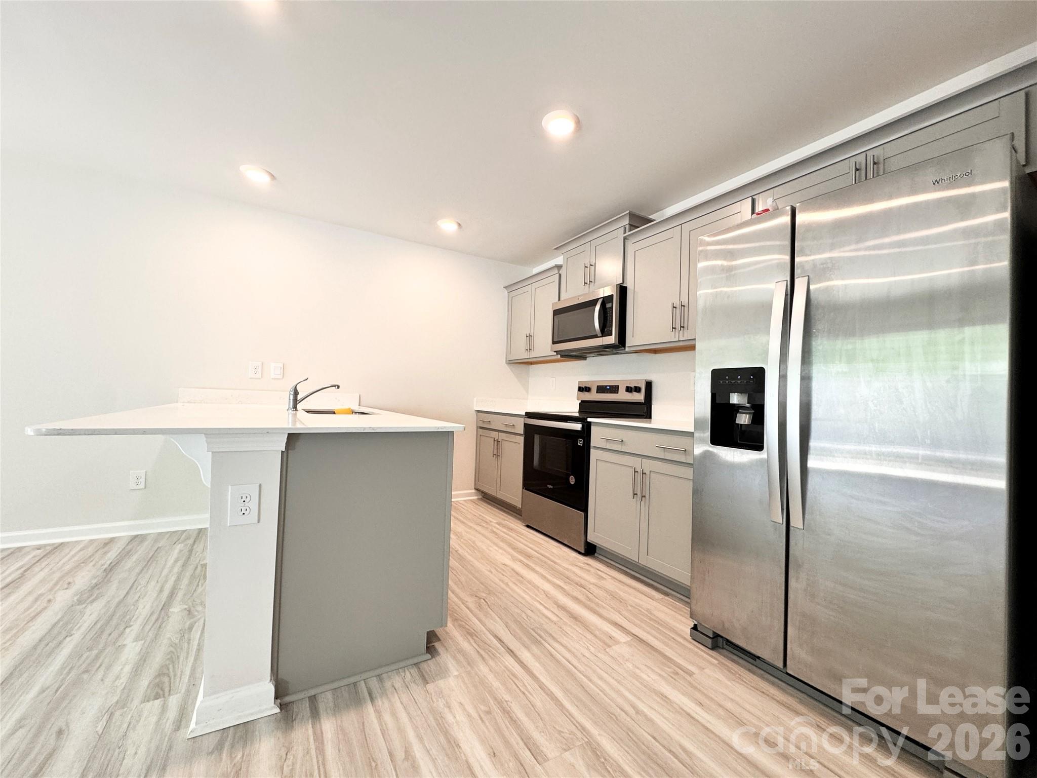 6131 Faron Way Charlotte, NC 28262 - Photo 3 of 18 a kitchen with a refrigerator a sink and a stove