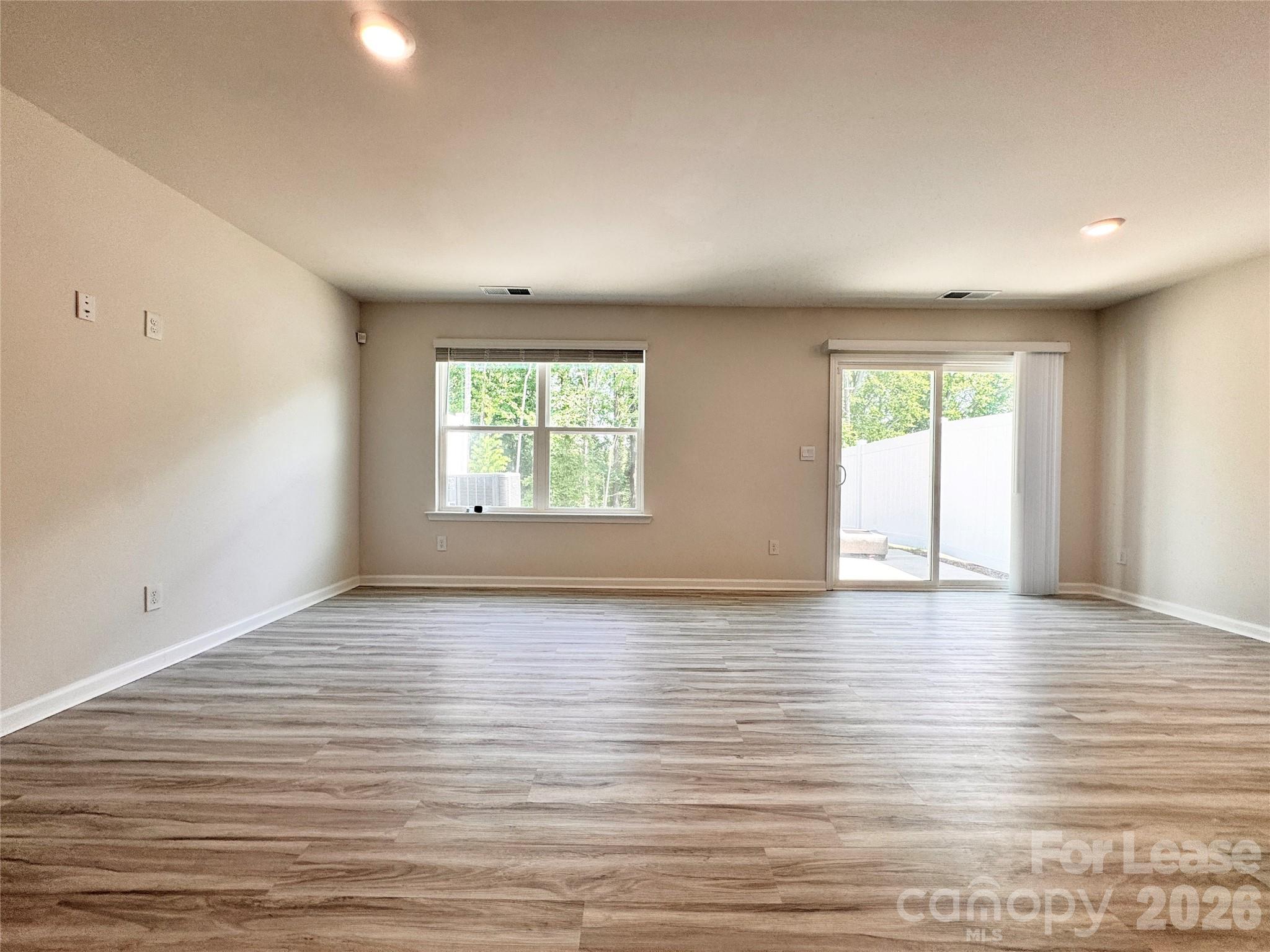 6131 Faron Way Charlotte, NC 28262 - Photo 7 of 18 an empty room with wooden floor and windows