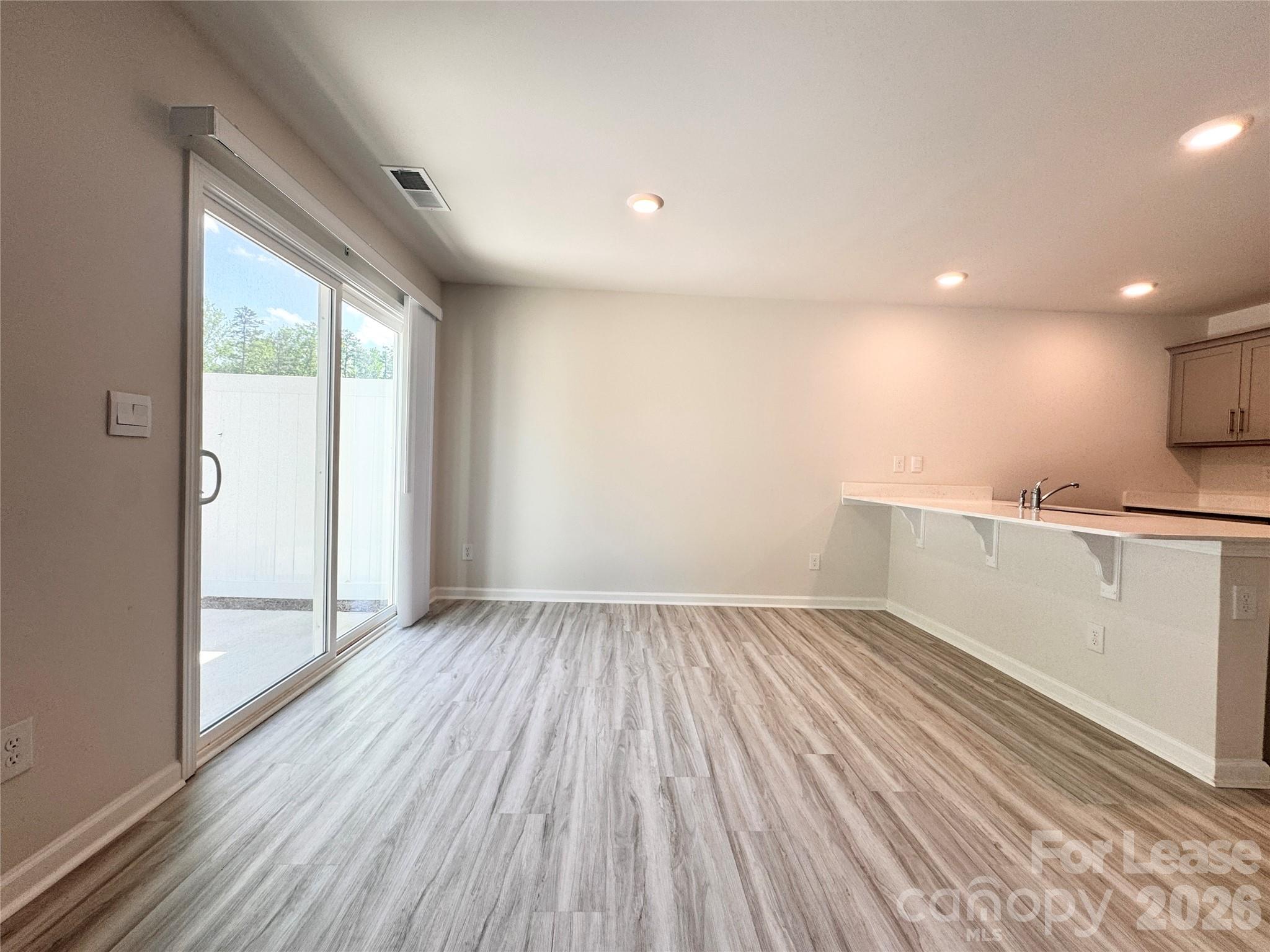 6131 Faron Way Charlotte, NC 28262 - Photo 8 of 18 a view of an empty room with wooden floor and a window