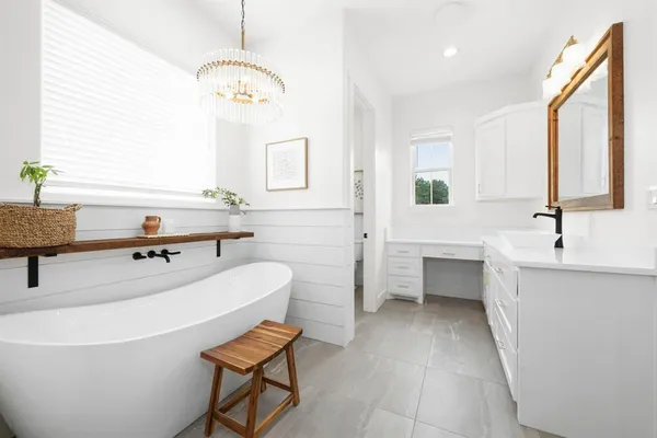 a bathroom with a tub sink and mirror