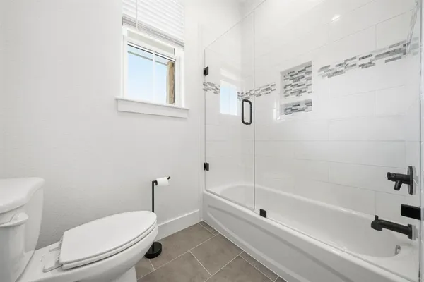a bathroom with a toilet and a shower