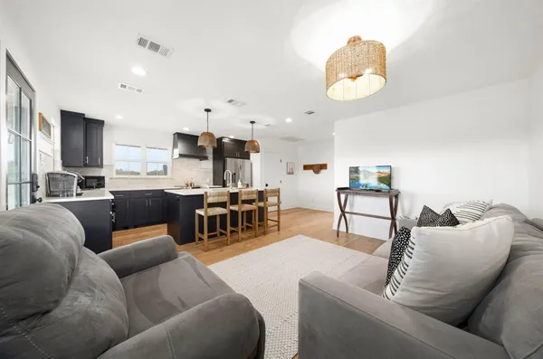 a living room with furniture and kitchen view