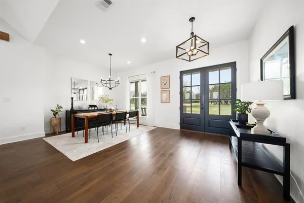 a living room with furniture a dining table and a large window