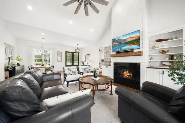 a living room with furniture a flat screen tv and a fireplace