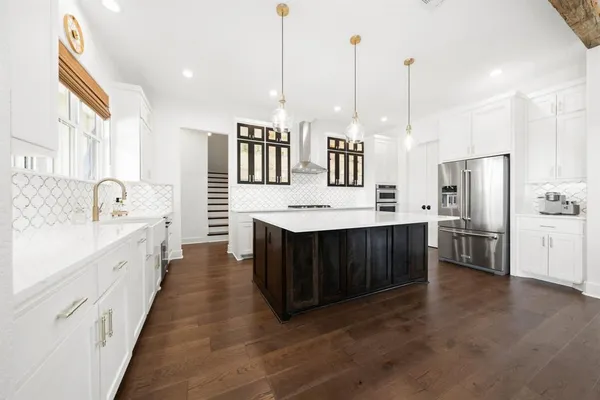 a kitchen with stainless steel appliances kitchen island granite countertop a sink a stove and a refrigerator