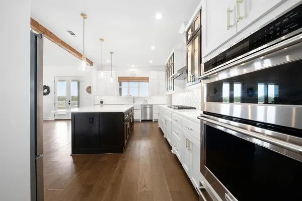 a kitchen with stainless steel appliances kitchen island a large stove a sink dishwasher and a refrigerator