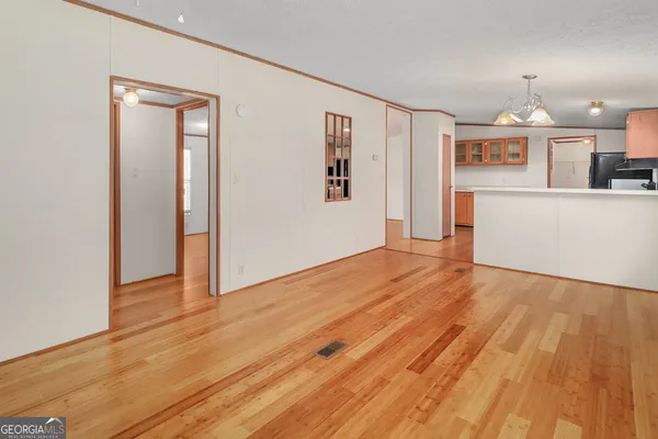 a view of a room with wooden floor and a ceiling fan