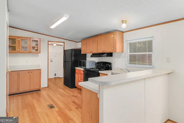 a kitchen with a refrigerator a stove top oven a sink and dishwasher with wooden floor