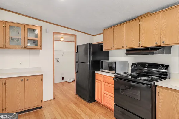 a kitchen with a refrigerator stove and wooden cabinets
