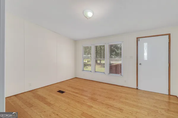 wooden floor in an empty room with a window