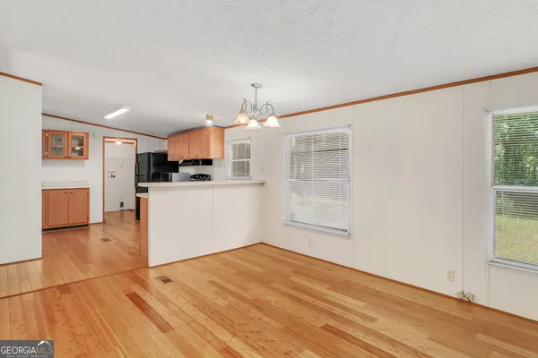 a view of a kitchen with wooden floor and a window