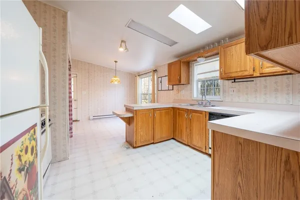 a view of kitchen with granite countertop a sink and a refrigerator