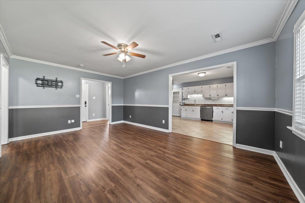 9496 Holly Grove Road Brighton, TN 38011 - Photo 8 of 29 Unfurnished living room with ornamental molding, a ceiling fan, and dark wood-style floors
