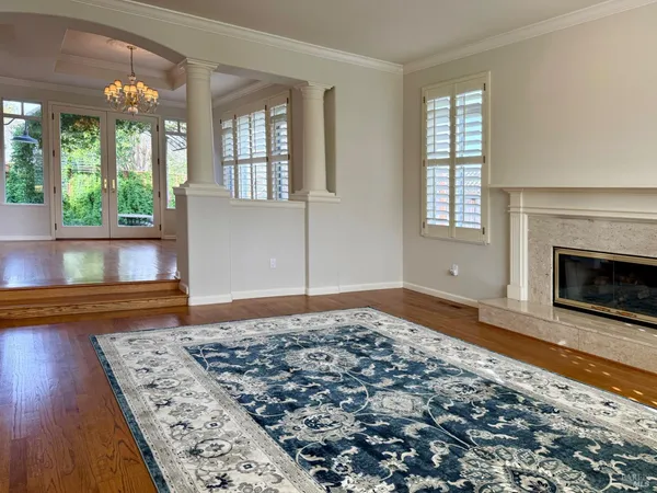 an empty room with floor to ceiling window and wooden floor