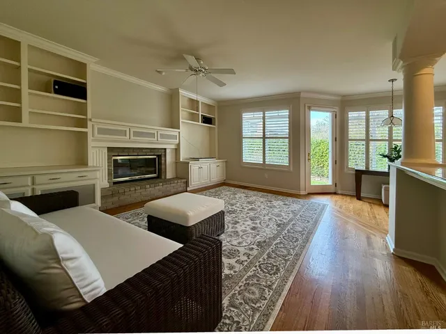 a view of a big room with wooden floor and windows
