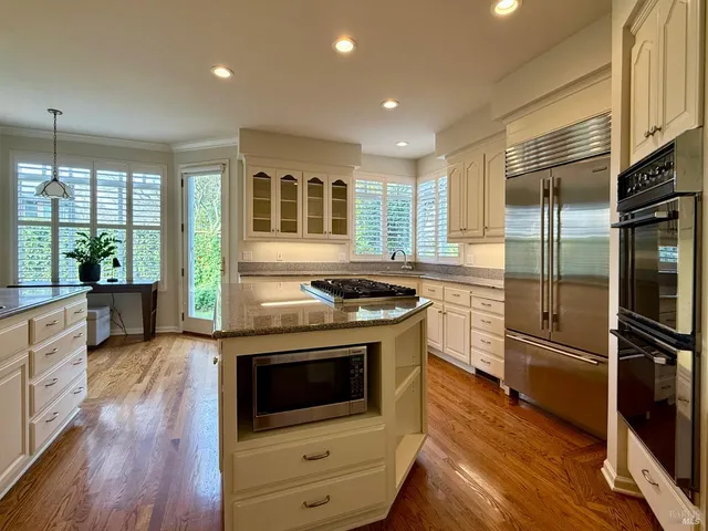 a kitchen with granite countertop a sink stove and cabinets