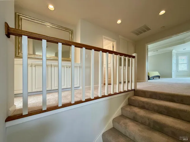 a bedroom with a bed table and two windows