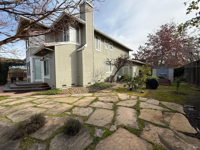 a view of a house with backyard and wooden fence