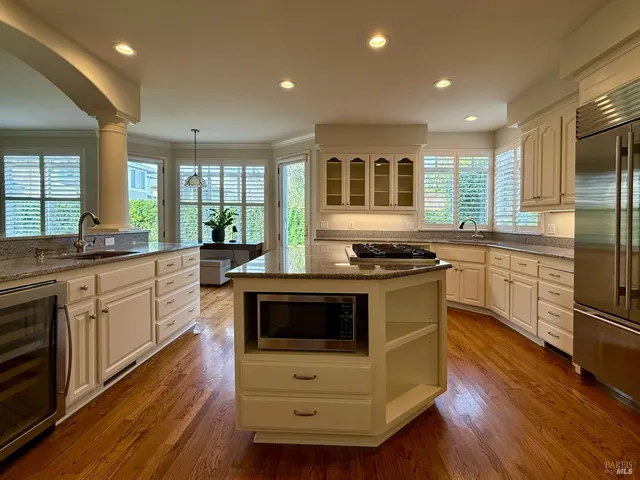 a kitchen with stainless steel appliances kitchen island granite countertop a stove a sink and a refrigerator