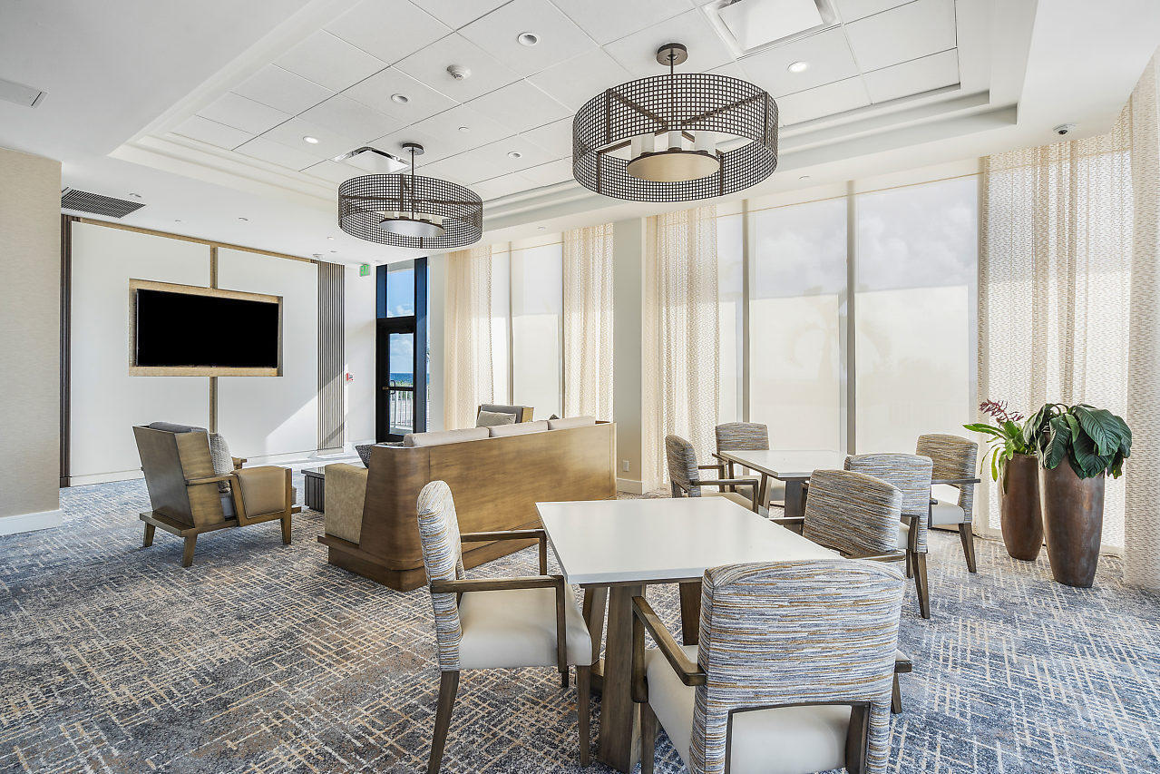 2600 South Ocean Boulevard, Unit 3E Boca Raton, FL 33432 - Photo 36 of 56 a living room with furniture a chandelier and a flat screen tv