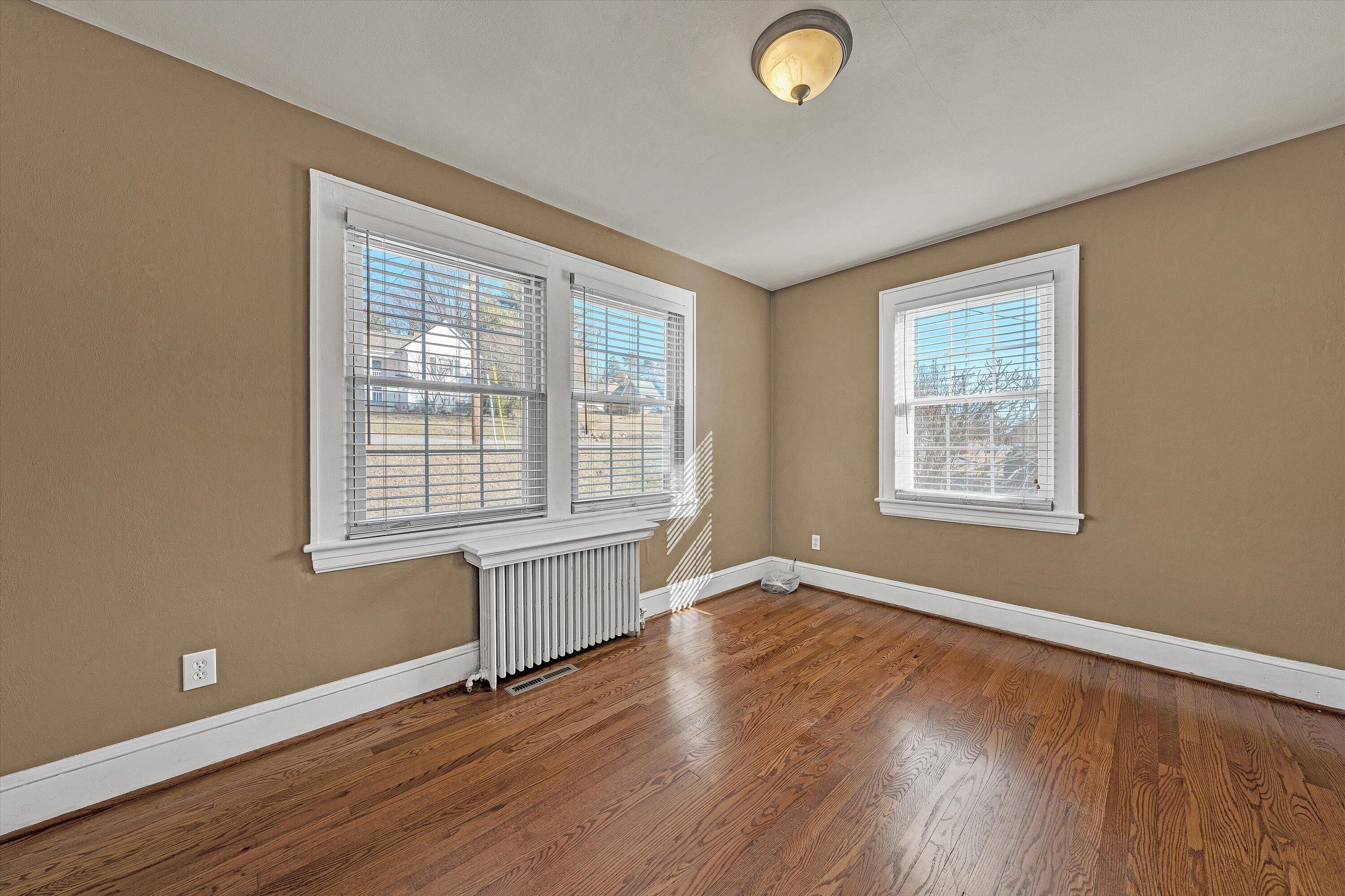 810 Windsor Avenue Southwest Roanoke, VA 24015 - Photo 11 of 21 an empty room with wooden floor and windows