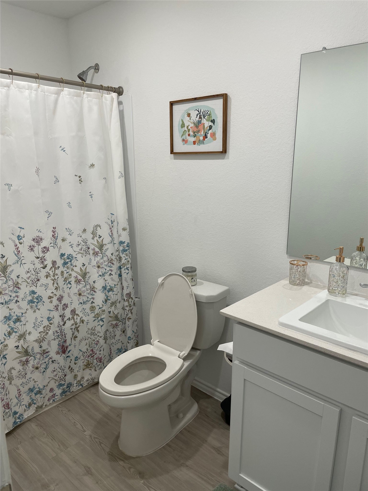 212 Marty Allen Loop Jarrell, TX 76537 - Photo 12 of 13 Bathroom featuring a white vanity with a rectangular undermount sink, a light-toned countertop, and light wood-finish flooring