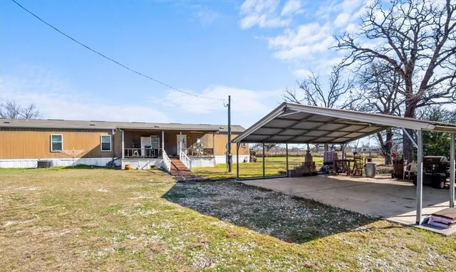 a view of a house with a backyard and sitting area