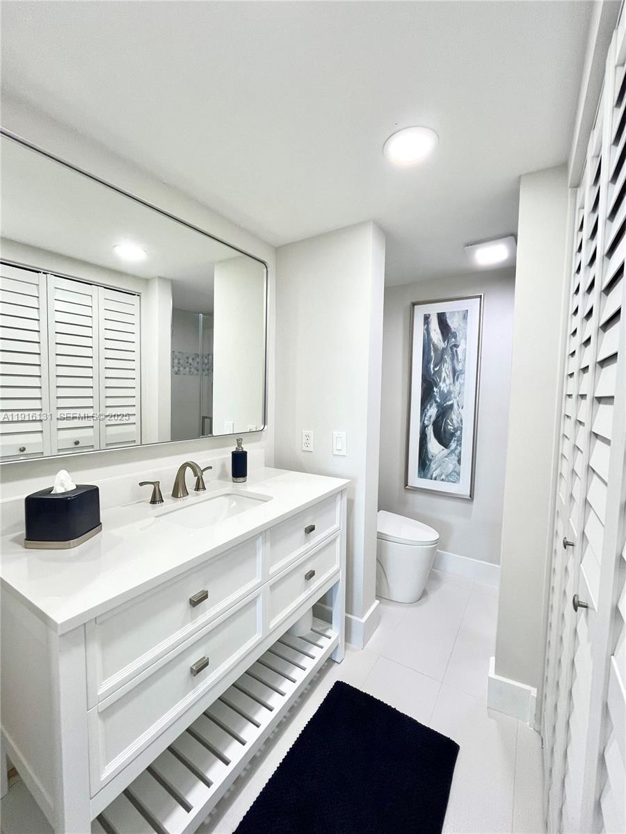 250 Northeast 20th Street, Unit 5250 Boca Raton, FL 33431 - Photo 11 of 19 a bathroom with a double vanity sink toilet and a window