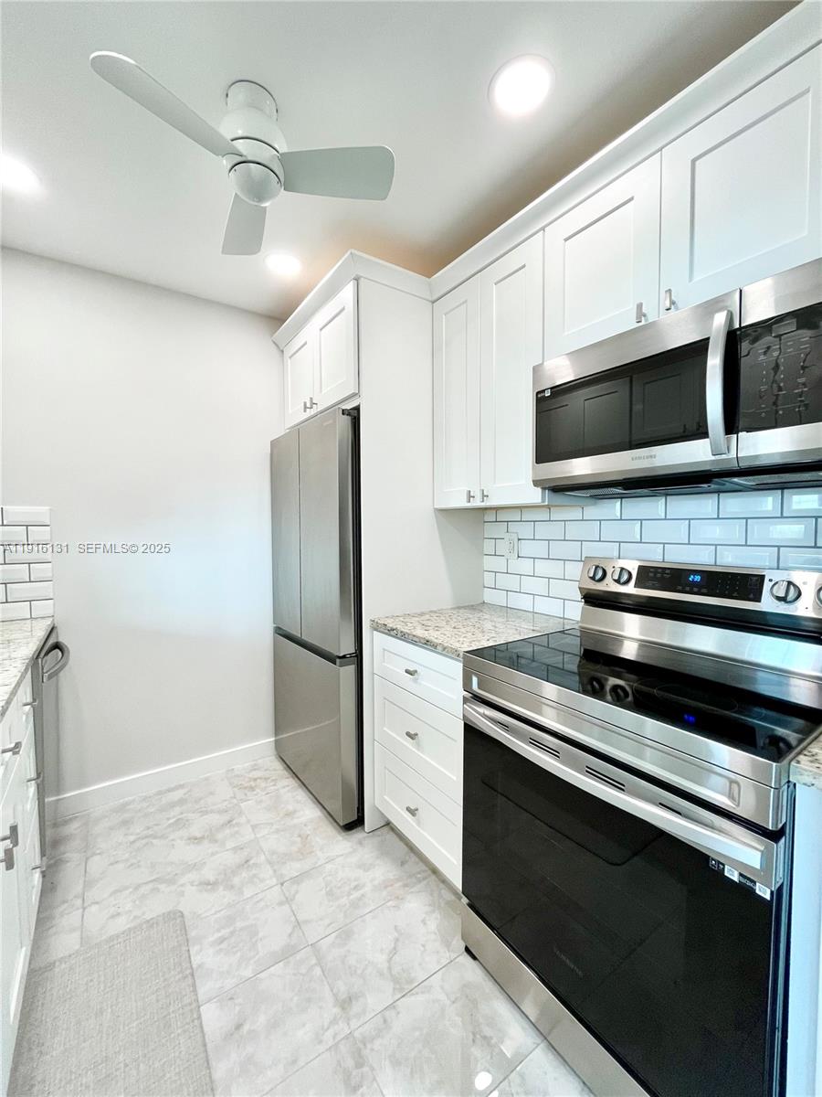 250 Northeast 20th Street, Unit 5250 Boca Raton, FL 33431 - Photo 14 of 19 a kitchen with a refrigerator stove and white cabinets