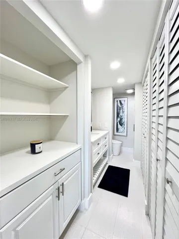 a walk in closet with view of bathroom