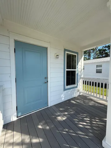 a living room with stainless steel appliances furniture a rug and a view of kitchen