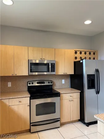 a kitchen with stainless steel appliances a stove a microwave and white cabinets