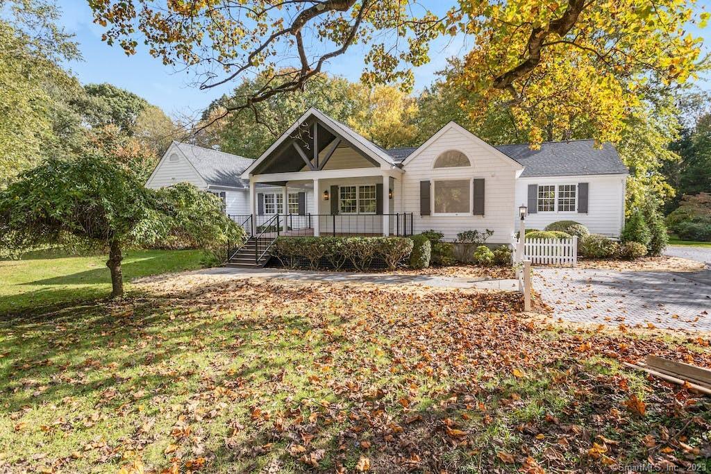 a front view of a house with a yard and trees