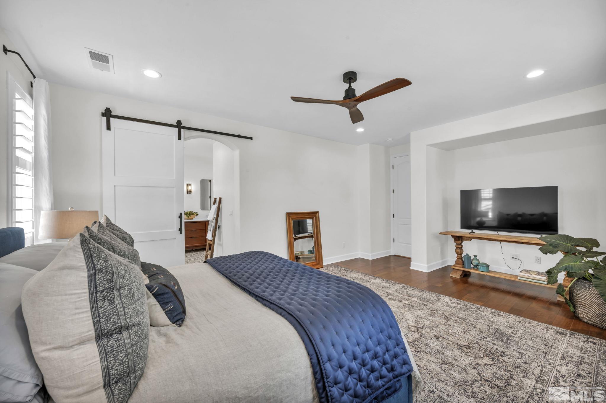 7665 Stone Bluff Way Reno, NV 89523 - Photo 26 of 40 a bedroom with a bed and a flat screen tv